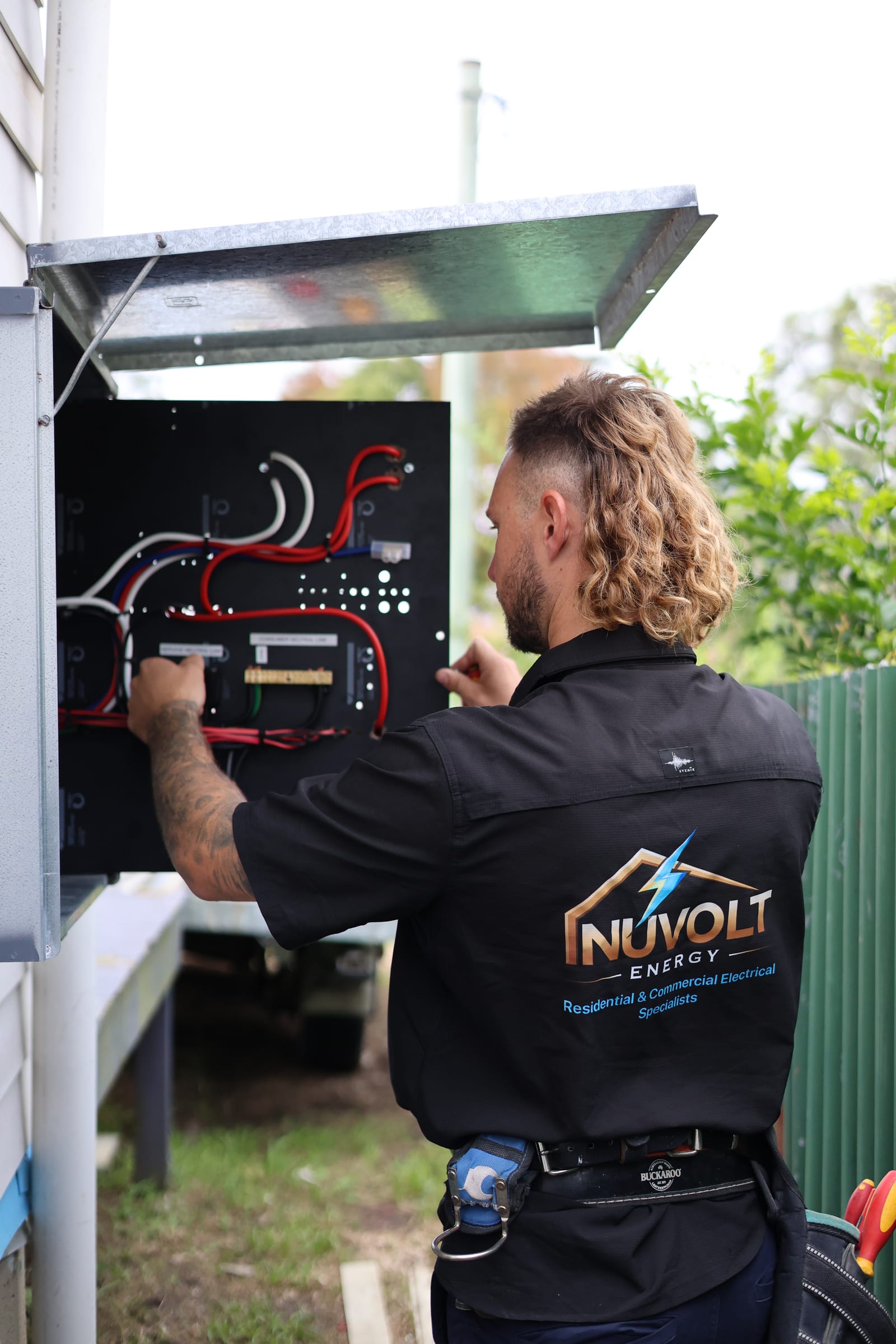 Cameron Hopkins of Nuvolt Energy installing a battery inverter panel on a Central Coast job