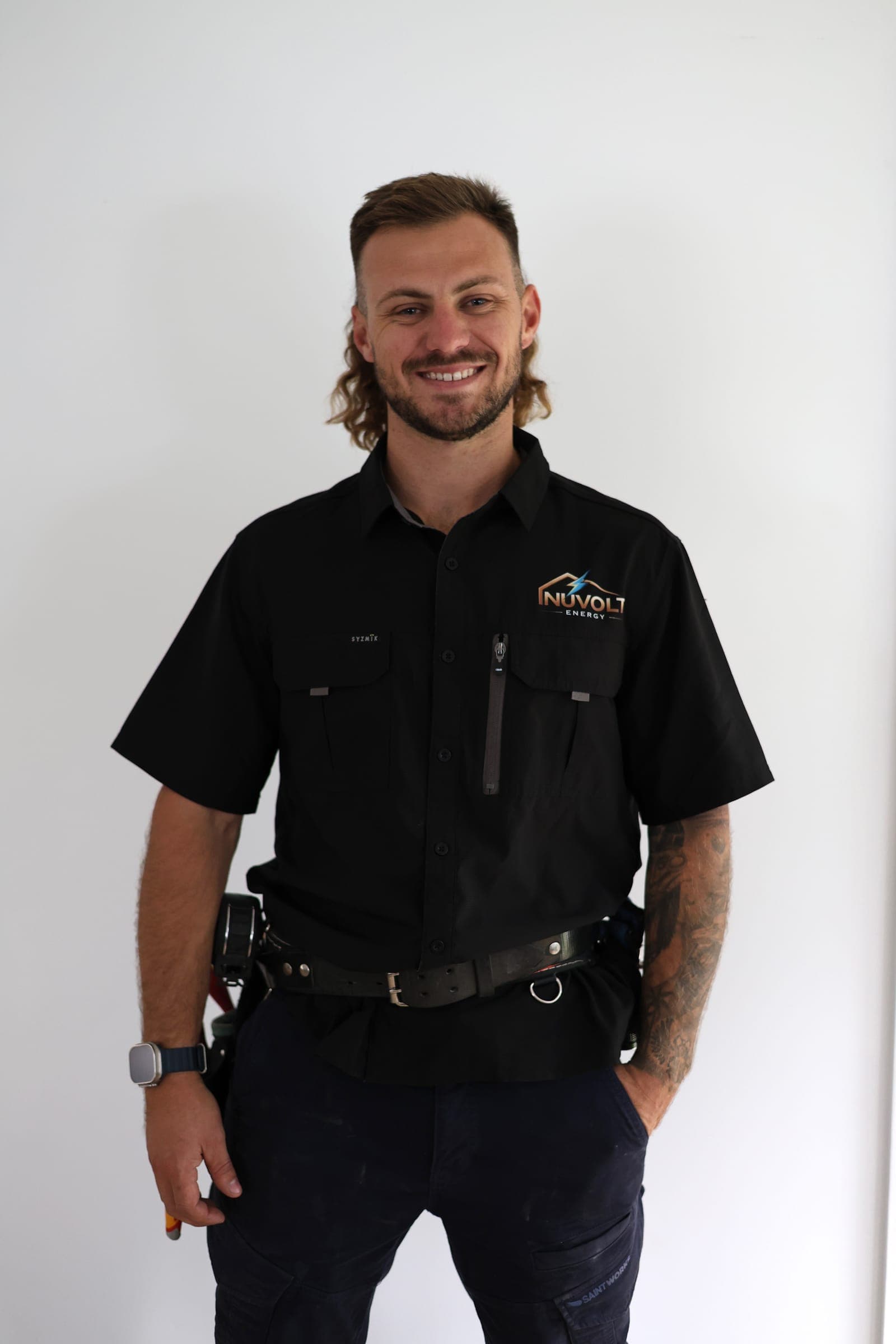 Cameron Hopkins of Nuvolt Energy — studio portrait in branded uniform with tool belt